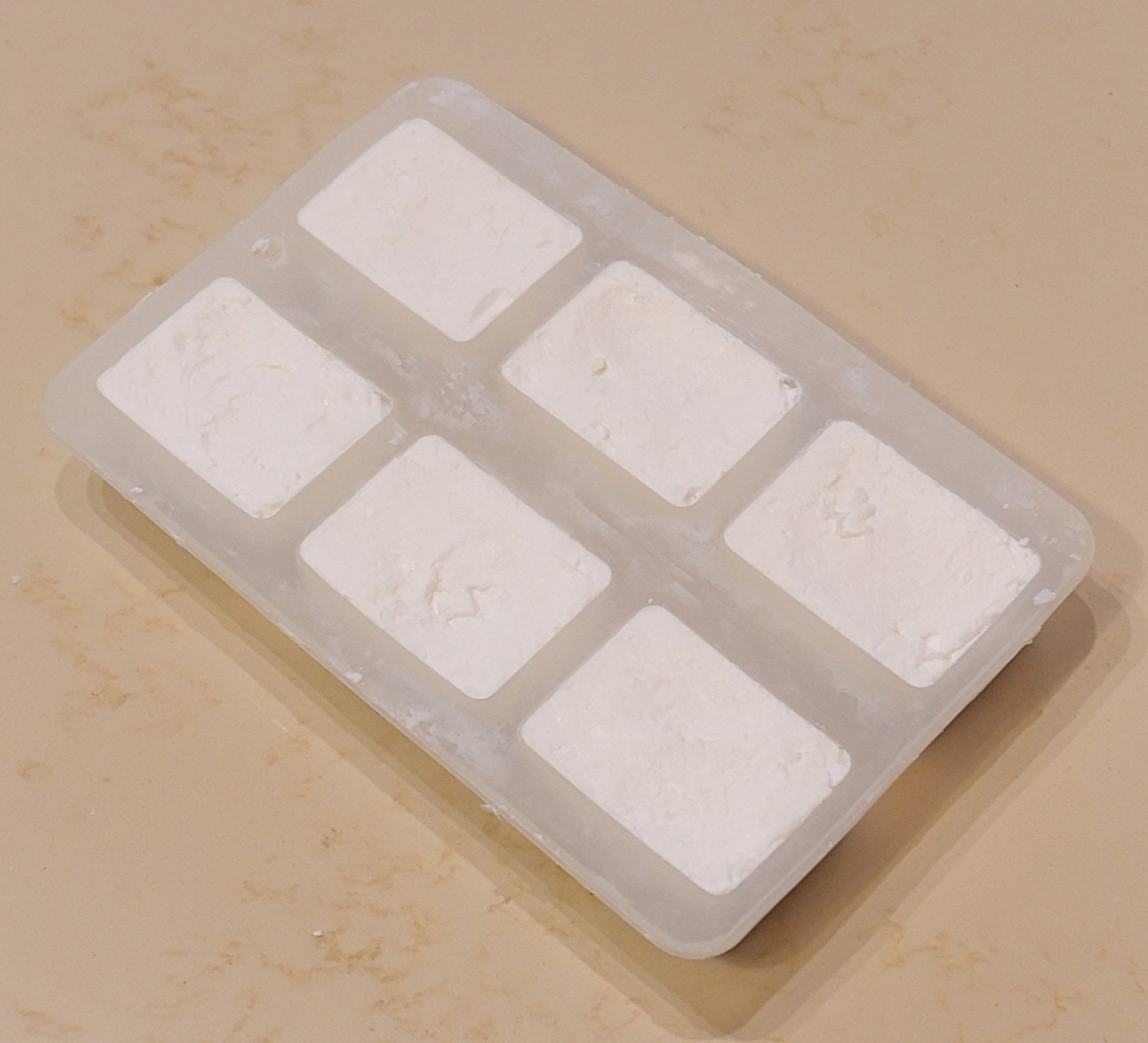 Photo: soap setting in wooden/silicone moulds on a curing rack.